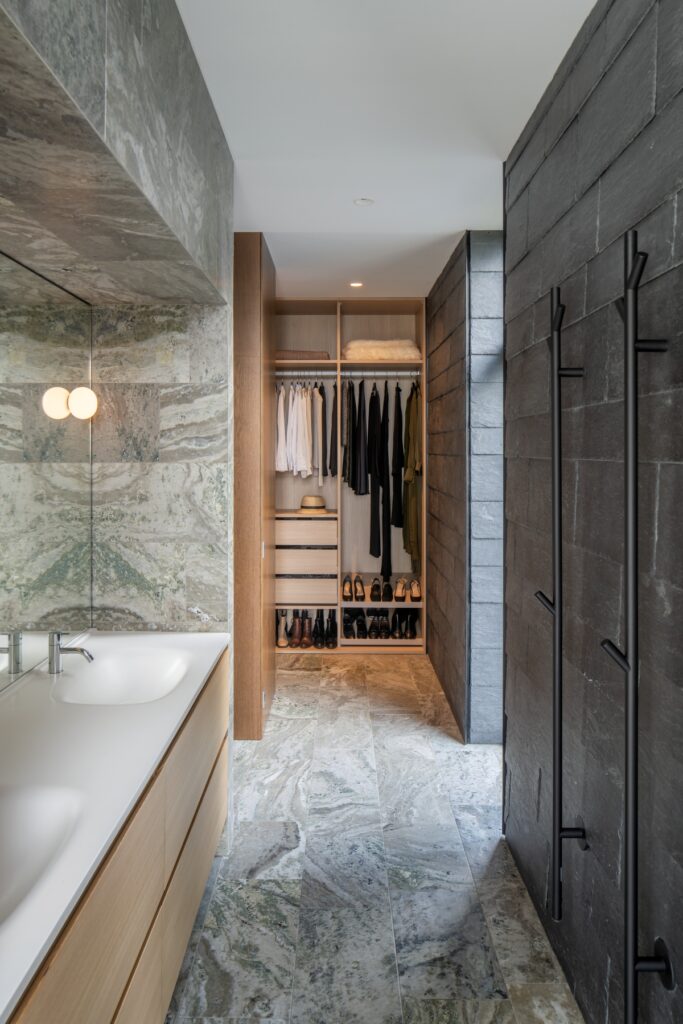 Luxury bathroom area with Swedish marble, double sink and towel rails; and a clothes storage area.
